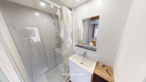 a white bathroom with a shower and a sink at Camping Officiel Siblu Bonne Anse Plage in La Palmyre