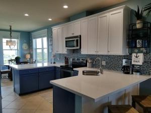 eine Küche mit blauen und weißen Schränken und einer Arbeitsplatte in der Unterkunft Unobstructed Beachfront Views at Private Beachfront Resort in Galveston