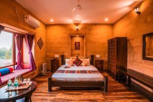 a bedroom with a bed and a bench in a room at Hotel Helsinki House in Jaisalmer