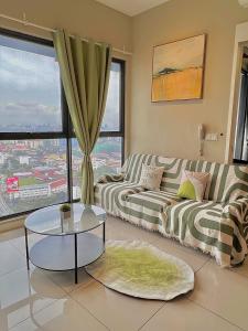 uma sala de estar com um sofá e uma mesa em KLCity 1BR Apartment SkyLounge em Kuala Lumpur