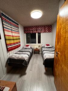 een kamer met 2 bedden en een raam erin bij Talo-Villa- 3 mh+s - Kittilä - Levi upea keittiö in Kittilä