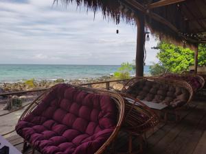 eine Couch auf einem Deck neben dem Meer in der Unterkunft Dreamer of the sea in Koh Rong Sanloem
