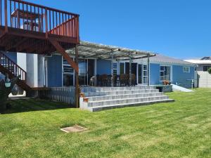 a blue house with a deck on a yard at Pêrel of Perlemoenbaai in Gansbaai