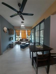 a living room with a ceiling fan and a table at Jesselton Quay Rashzia Kota kinabalu in Kota Kinabalu