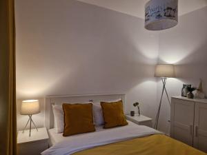 Un dormitorio con una cama con almohadas amarillas. en MV Central Apartment & Garage - Self Check-in, en Timisoara