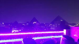 een uitzicht op een fontein in de nacht met de piramides bij Gohar Guest House in Caïro