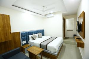 a hotel room with a bed and a television at HOTEL GOLDEN CITY in Surat