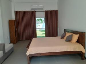 een slaapkamer met een groot bed en een raam bij Abhishek Villa in Kekanadura