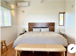 a bedroom with a large bed with a wooden headboard at ハルク キャビン in Nakijin +36 photos