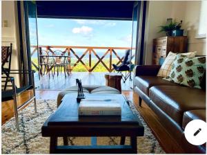 a living room with a couch and a table and a balcony at ハルク キャビン in Nakijin