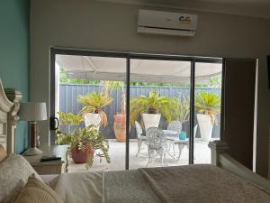 une chambre avec un lit et une terrasse avec des plantes en pot dans l'établissement Koombana Retreat, à Perth