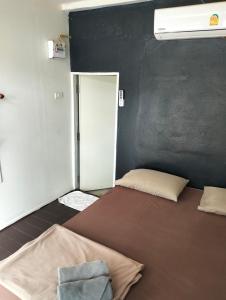 Habitación pequeña con cama y puerta blanca en Patoo en Ko Chang