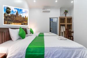 a bedroom with a large green and white bed at The Khmer House Villas in Siem Reap