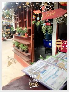 a store with potted plants and a sign in front of it at MR Mo Guest House in Muang Không