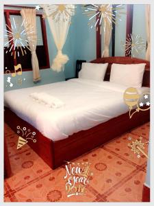 a bedroom with a large bed with white sheets at MR Mo Guest House in Muang Không