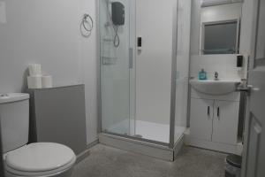a bathroom with a shower and a toilet and a sink at Royal Hotel Kettering in Kettering