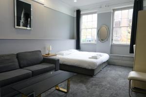 1 dormitorio con 1 cama y 1 sofá en Royal Hotel Kettering en Kettering