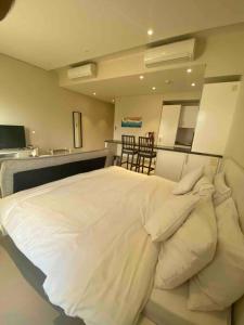 a bedroom with a large bed with white pillows at Lovely studio apartment inside Jebel Sifah resort in As Sīfah