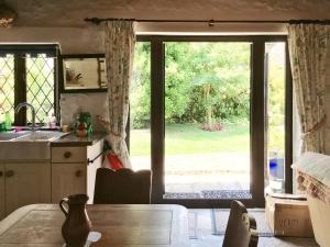 una cocina con una puerta corredera de cristal que da a un patio en Little Whitnell Cottage, en Nether Stowey