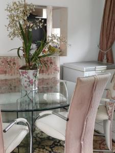 szklany stół i krzesła z wazonem kwiatów w obiekcie Margate Accomodation w mieście Margate