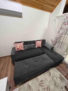 a black couch sitting in a living room at SAKLIBAHÇE BUNGALOV in Buyukcekmece