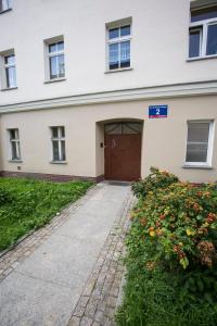 a building with a brown door and some flowers at Obok Poczty blisko Rynku in Wałbrzych