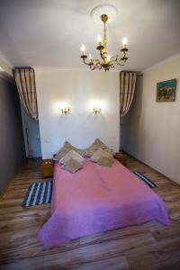 a bedroom with a large purple bed with a chandelier at Obok Poczty blisko Rynku in Wałbrzych