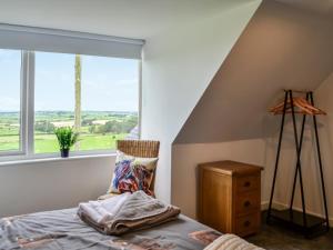 a bedroom with a bed and a large window at Muirston Farmhouse in Ochiltree