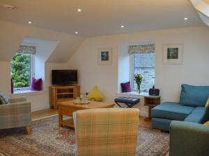 a living room with a blue couch and a tv at Cottage No,2 - Uk41847 in Aberfeldy