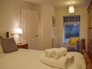 a bedroom with a bed with towels on it at Cottage No,2 - Uk41847 in Aberfeldy