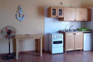 una cucina con piano cottura, tavolo e ventilatore di Appartamento BICA. Stella Maris Exclusive a Calheta Do Maio