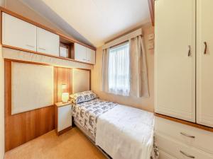 una piccola camera con letto e finestra di Hafod Caravan - Uk45717 a Brynteg