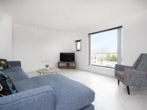 sala de estar con 2 sofás azules y TV en Caledonia View en Aviemore