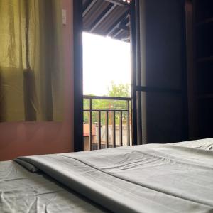 a bedroom with a bed and a window with a balcony at Alona Princess Suites in Panglao