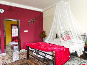 een slaapkamer met een bed met een klamboe bij Mannat Inn Homestay (Mysore) in Mysore