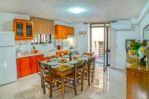 eine Küche mit einem Tisch und Stühlen sowie einem Kühlschrank in der Unterkunft Kiki's House near Falassarna and Balos in Plátanos