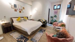 a bedroom with a bed and two chairs in it at Youngnn Hostel in Lukang