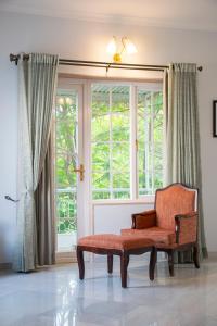 a chair sitting in front of a window at Naila Kothi, Jaipur in Jaipur