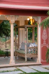 a porch with a swing on a house at Naila Kothi, Jaipur in Jaipur