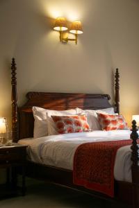 a bedroom with a bed with pillows and two lamps at Naila Kothi, Jaipur in Jaipur