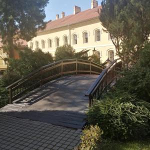 un pont en bois sur une passerelle devant un bâtiment dans l'établissement Apartman Classic, à Komárno