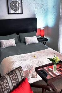 a bedroom with a bed with a table on it at Salty Soul Studio 70 in Roodepoort