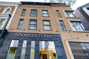 un bâtiment en briques portant le nom de Sherriticism inn dans l'établissement The Shoreditch Inn, à Londres