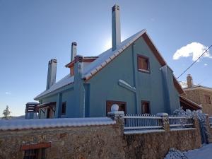 Synikia Mesi TrikalonにあるGuesthouse Italianoの雪の中に柵を持つ青い家