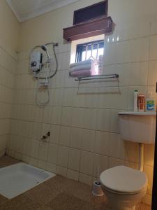 a bathroom with a toilet and a window at Pentacasa in Jinja