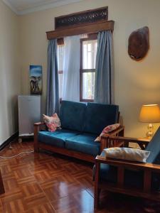 Pentacasa في جينجا: غرفة معيشة مع أريكة زرقاء ونافذة
