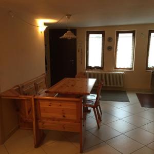 ein Esszimmer mit einem Holztisch und Stühlen in der Unterkunft Appartamento il Nido in Moena