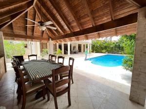 comedor con mesa, sillas y piscina en Metro Golf Villa, en Paraíso