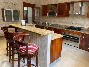 una cocina con isla con taburetes de bar en Metro Golf Villa, en Paraíso