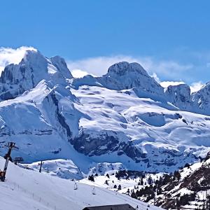 vistas a una montaña cubierta de nieve con una pista de esquí en Albergue Tritón - Villanúa, en Villanúa